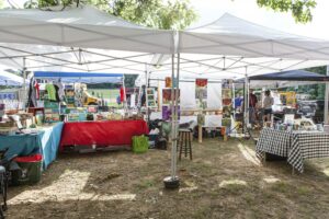 Events at a farm showing tents and tables selling books and flower photo art.